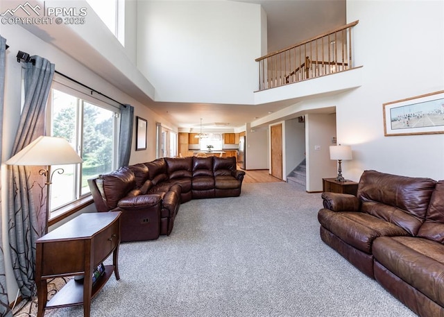 2457 Craycroft Dr, Colorado Springs, CO 80920 - living room with light colored carpet, stairs, a high ceiling, and plenty of natural light