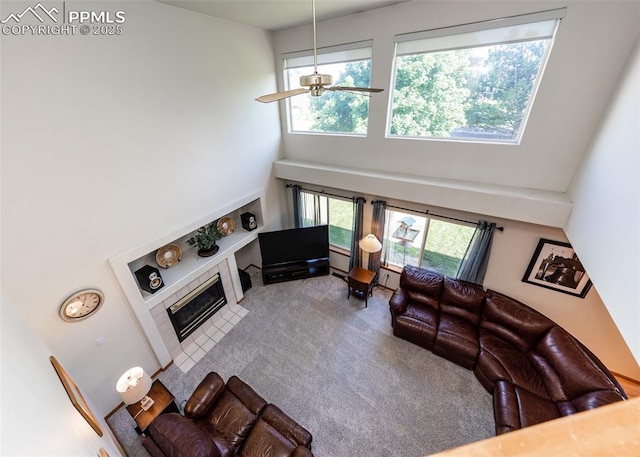 2457 Craycroft Dr, Colorado Springs, CO 80920 - carpeted living area featuring a towering ceiling, ceiling fan, and a tiled fireplace