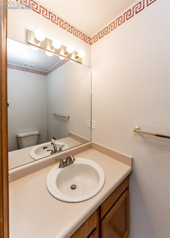 2457 Craycroft Dr, Colorado Springs, CO 80920 - half bathroom with vanity and toilet
