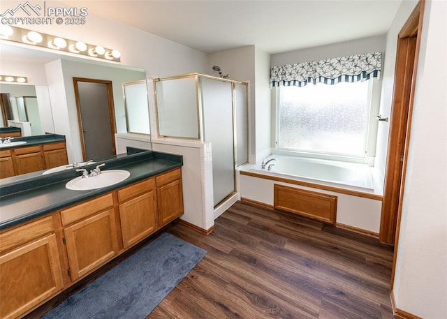 2457 Craycroft Dr, Colorado Springs, CO 80920 - bathroom featuring a shower stall, a garden tub, wood finished floors, and vanity