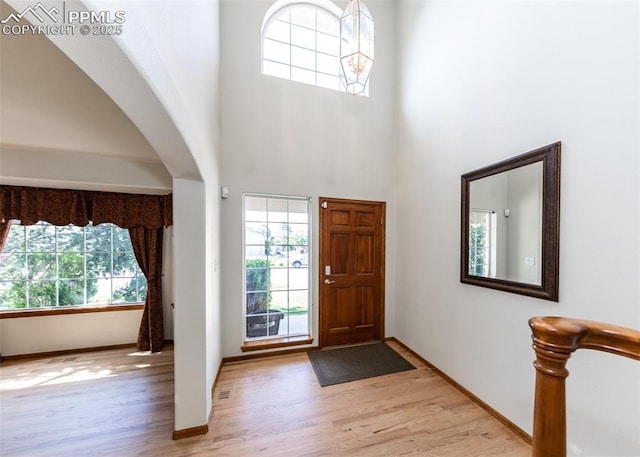 2457 Craycroft Dr, Colorado Springs, CO 80920 - foyer entrance with healthy amount of natural light, wood finished floors, arched walkways, and a towering ceiling