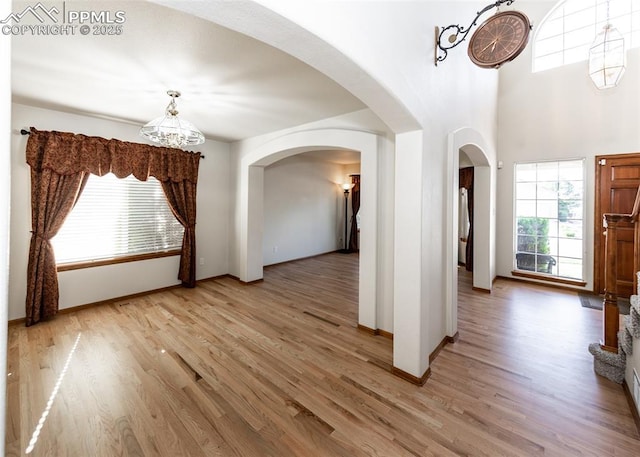 2457 Craycroft Dr, Colorado Springs, CO 80920 - entrance foyer featuring arched walkways, light wood finished floors, and a chandelier
