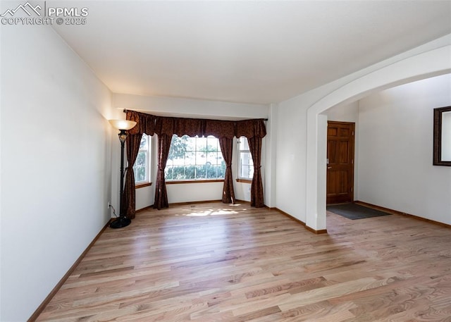 2457 Craycroft Dr, Colorado Springs, CO 80920 - empty room with arched walkways and light wood finished floors