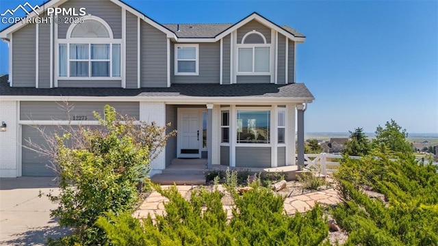 12275 Oregon Wagon Trl, Elbert, CO 80106 - view of front of home featuring an attached garage, brick siding, a shingled roof, and driveway