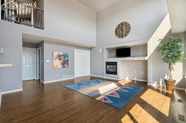 12275 Oregon Wagon Trl, Elbert, CO 80106 - living area with a high ceiling, wood finished floors, and a glass covered fireplace
