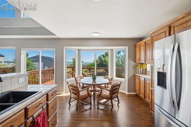 12275 Oregon Wagon Trl, Elbert, CO 80106 - kitchen with stainless steel fridge with ice dispenser, tile counters, dark wood-style floors, and brown cabinetry