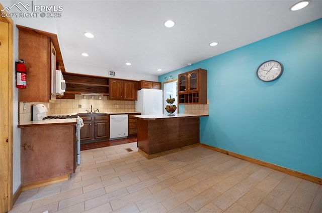 1112 W 4th St, Florence, CO 81226 - kitchen featuring white appliances, a peninsula, open shelves, tasteful backsplash, and glass insert cabinets