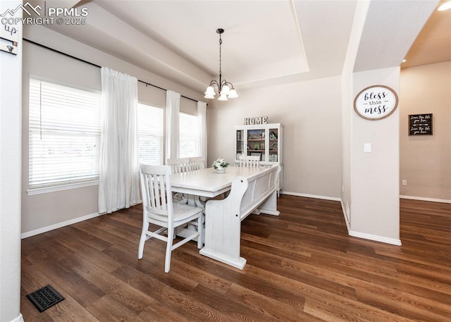 7145 Appletree Loop, Colorado Springs, CO 80925 - dining area featuring dark wood-style flooring, a chandelier, and a tray ceiling