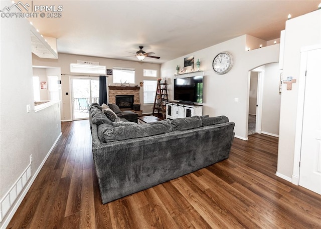 7145 Appletree Loop, Colorado Springs, CO 80925 - living area with ceiling fan, arched walkways, wood finished floors, and a fireplace