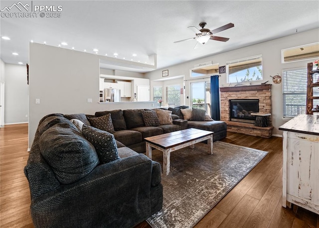 7145 Appletree Loop, Colorado Springs, CO 80925 - living area featuring recessed lighting, healthy amount of natural light, a ceiling fan, wood finished floors, and a fireplace