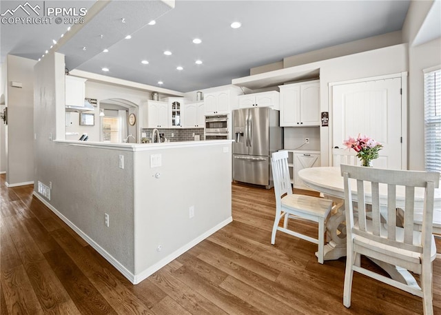 7145 Appletree Loop, Colorado Springs, CO 80925 - kitchen with appliances with stainless steel finishes, glass insert cabinets, white cabinetry, recessed lighting, and dark wood-style flooring