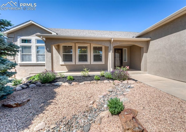 7145 Appletree Loop, Colorado Springs, CO 80925 - doorway to property featuring stucco siding and a porch