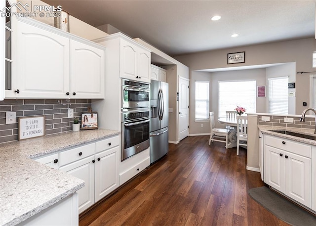 7145 Appletree Loop, Colorado Springs, CO 80925 - kitchen featuring stainless steel fridge, recessed lighting, white cabinetry, backsplash, and healthy amount of natural light