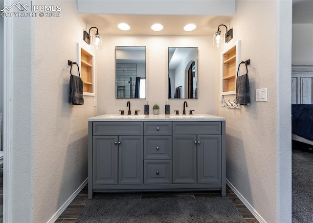 7145 Appletree Loop, Colorado Springs, CO 80925 - bathroom with double vanity, wood finished floors, built in shelves, and a textured wall