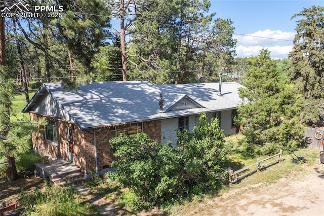 12185 Black Forest Rd, Colorado Springs, CO 80908 - view of front of house featuring brick siding and roof with shingles