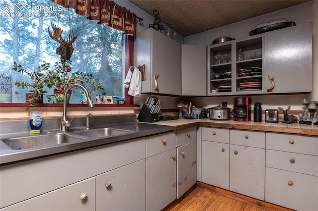 12185 Black Forest Rd, Colorado Springs, CO 80908 - kitchen featuring open shelves, a textured ceiling, light wood-style flooring, white cabinetry, and light countertops