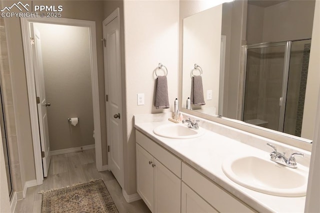 8176 Kittrick Pl, Peyton, CO 80831 - bathroom with a stall shower, double vanity, and wood finished floors