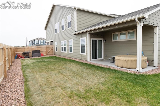8176 Kittrick Pl, Peyton, CO 80831 - back of house featuring a hot tub, a fenced backyard, roof with shingles, and a patio