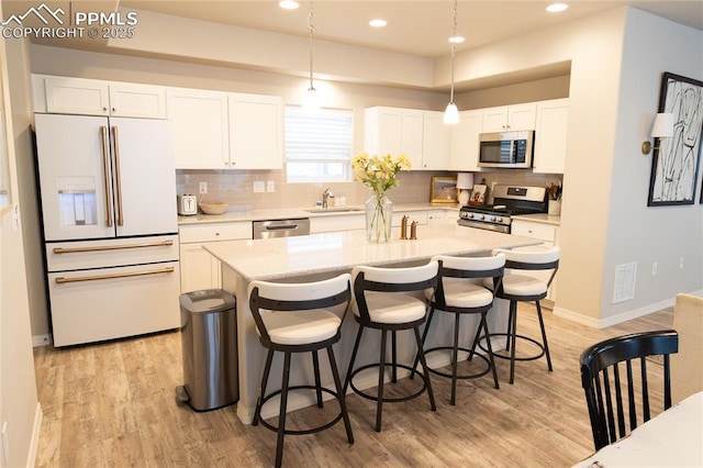 8176 Kittrick Pl, Peyton, CO 80831 - kitchen with appliances with stainless steel finishes, light wood finished floors, light countertops, backsplash, and recessed lighting