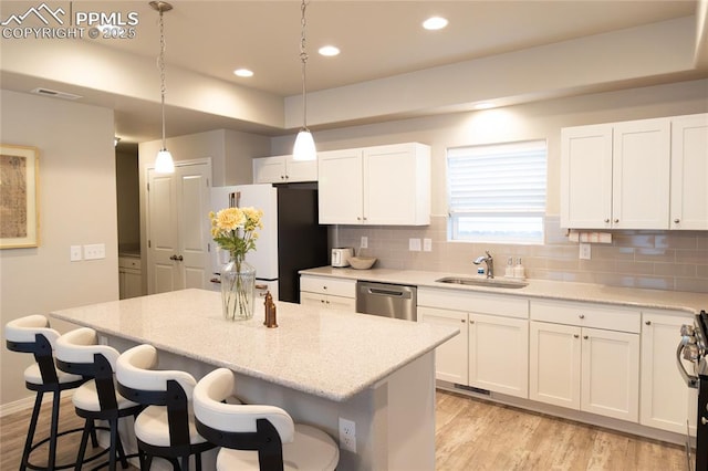 8176 Kittrick Pl, Peyton, CO 80831 - kitchen with appliances with stainless steel finishes, light wood-style floors, tasteful backsplash, a center island, and recessed lighting