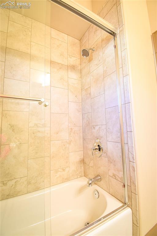 5707 Mark Twain Ln, Pueblo, CO 81008 - bathroom featuring combined bath / shower with glass door
