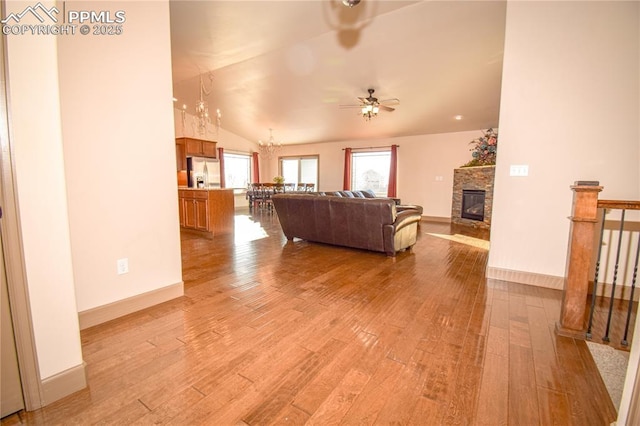 5707 Mark Twain Ln, Pueblo, CO 81008 - living room with light wood-type flooring, a ceiling fan, lofted ceiling, and a fireplace