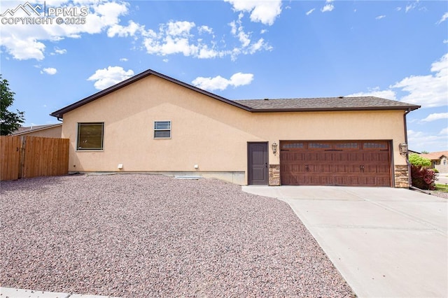 5707 Mark Twain Ln, Pueblo, CO 81008 - view of front of property featuring stucco siding, a garage, concrete driveway, and stone siding