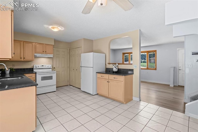 5888 Eldora Dr, Colorado Springs, CO 80918 - kitchen with white appliances, under cabinet range hood, light brown cabinetry, dark countertops, and light tile patterned flooring