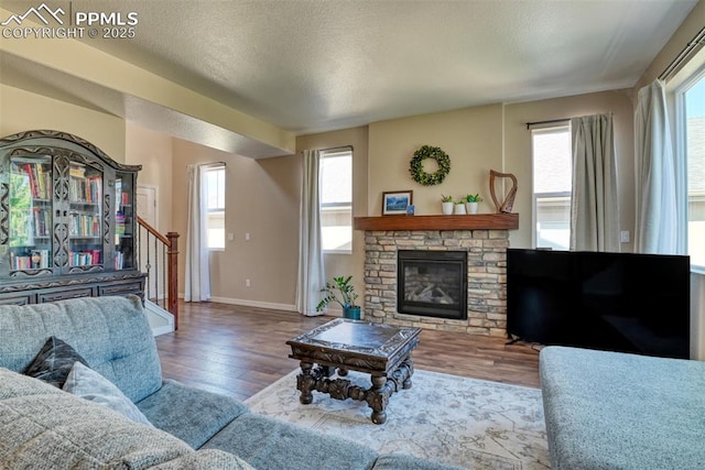 3470 Daydreamer Dr, Colorado Springs, CO 80908 - living area featuring wood finished floors, stairway, a fireplace, and a textured ceiling