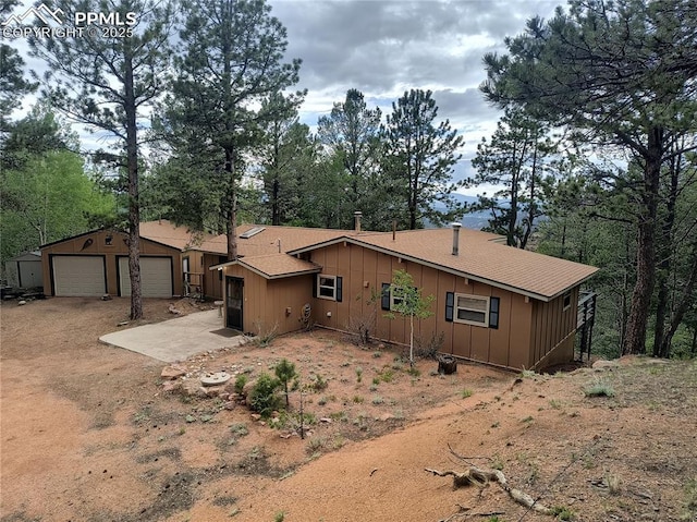 237 Blue Spruce Rd, Divide, CO 80814 - view of front of home featuring board and batten siding, driveway, a garage, and roof with shingles