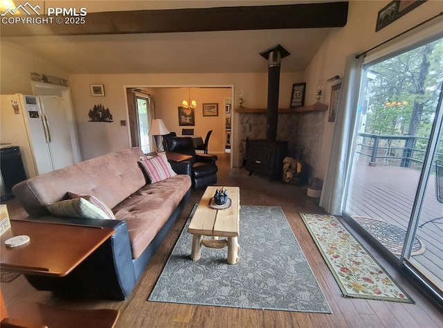 237 Blue Spruce Rd, Divide, CO 80814 - living room with a chandelier, a wood stove, wood finished floors, healthy amount of natural light, and beamed ceiling