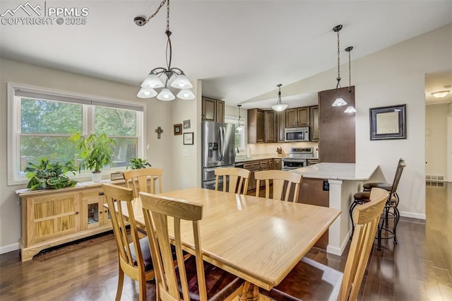 4734 Bunchberry Ln, Colorado Springs, CO 80917 - dining area with lofted ceiling, dark wood finished floors, and a chandelier