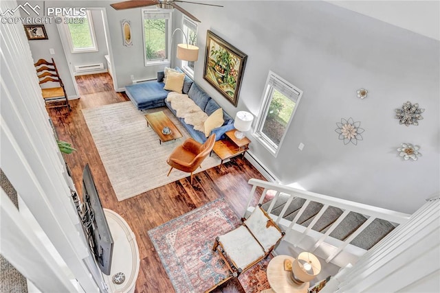531 N Cedar St, Colorado Springs, CO 80903 - living room with a baseboard radiator, wood finished floors, stairway, a baseboard heating unit, and a ceiling fan