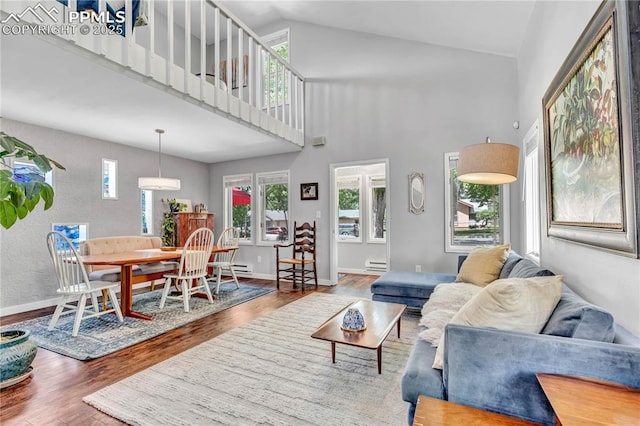 531 N Cedar St, Colorado Springs, CO 80903 - living area featuring wood finished floors, a baseboard heating unit, and high vaulted ceiling