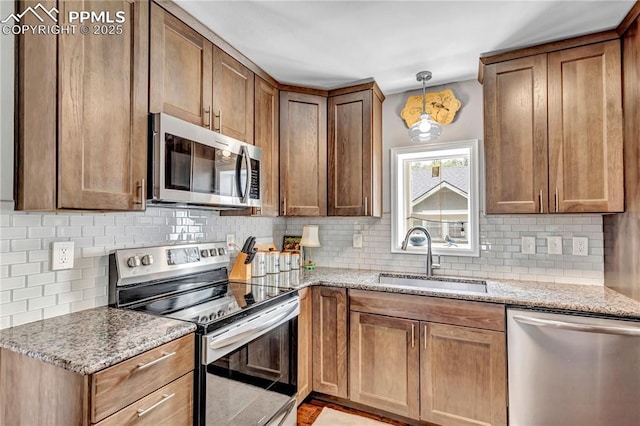 531 N Cedar St, Colorado Springs, CO 80903 - kitchen with stainless steel appliances, tasteful backsplash, light stone countertops, and decorative light fixtures