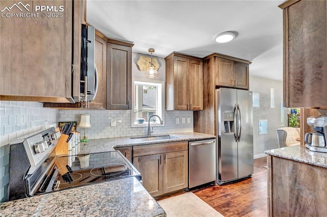 531 N Cedar St, Colorado Springs, CO 80903 - kitchen featuring appliances with stainless steel finishes, decorative backsplash, wood finished floors, and light stone counters