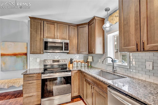531 N Cedar St, Colorado Springs, CO 80903 - kitchen with stainless steel appliances, light stone countertops, decorative backsplash, hanging light fixtures, and light wood-style flooring