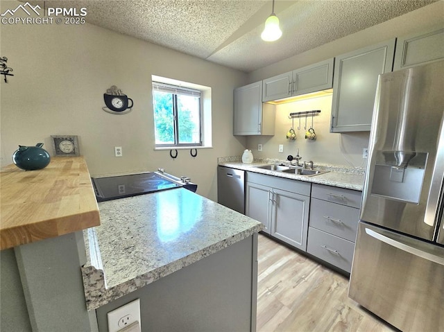 974 S Candlestar Loop, Fountain, CO 80817 - kitchen featuring stainless steel appliances, gray cabinets, light wood finished floors, a textured ceiling, and a peninsula