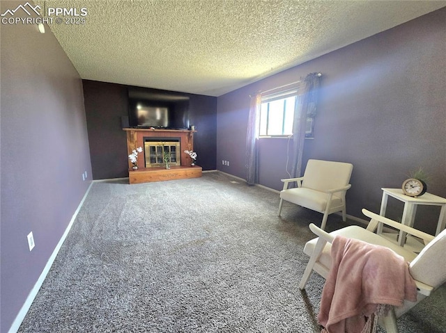 974 S Candlestar Loop, Fountain, CO 80817 - living area featuring a glass covered fireplace, a textured ceiling, and carpet floors