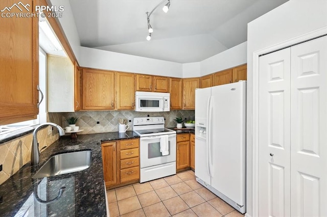 6275 Montarbor Dr, Colorado Springs, CO 80918 - kitchen with white appliances, vaulted ceiling, light tile patterned flooring, brown cabinets, and track lighting