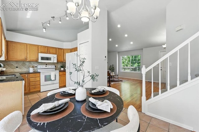 6275 Montarbor Dr, Colorado Springs, CO 80918 - kitchen with white appliances, lofted ceiling, light tile patterned floors, decorative backsplash, and a chandelier