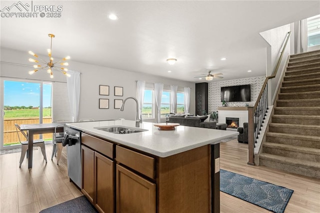 244 S Chipeta Way, Lochbuie, CO 80603 - kitchen featuring a warm lit fireplace, stainless steel dishwasher, light wood-type flooring, light countertops, and a chandelier
