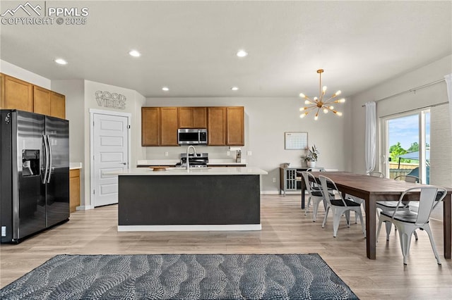 244 S Chipeta Way, Lochbuie, CO 80603 - kitchen with appliances with stainless steel finishes, a chandelier, light countertops, light wood-style flooring, and recessed lighting