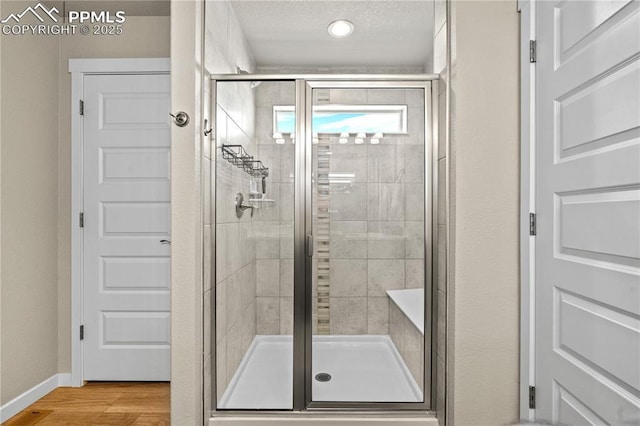 244 S Chipeta Way, Lochbuie, CO 80603 - bathroom with a stall shower and wood finished floors