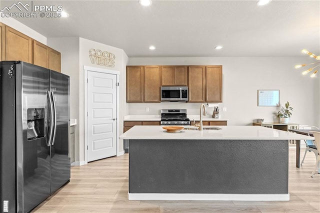 244 S Chipeta Way, Lochbuie, CO 80603 - kitchen featuring stainless steel appliances, light wood-style flooring, brown cabinetry, and recessed lighting