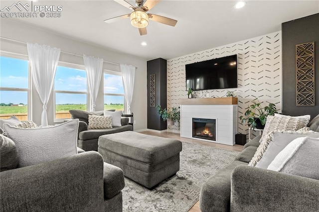 244 S Chipeta Way, Lochbuie, CO 80603 - living area featuring a ceiling fan, recessed lighting, a glass covered fireplace, and wood finished floors