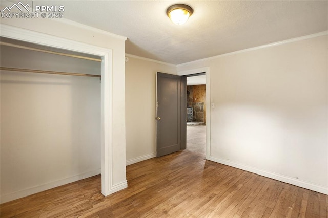 205 N Laurel St, Woodland Park, CO 80863 - unfurnished bedroom featuring crown molding, wood finished floors, and a closet