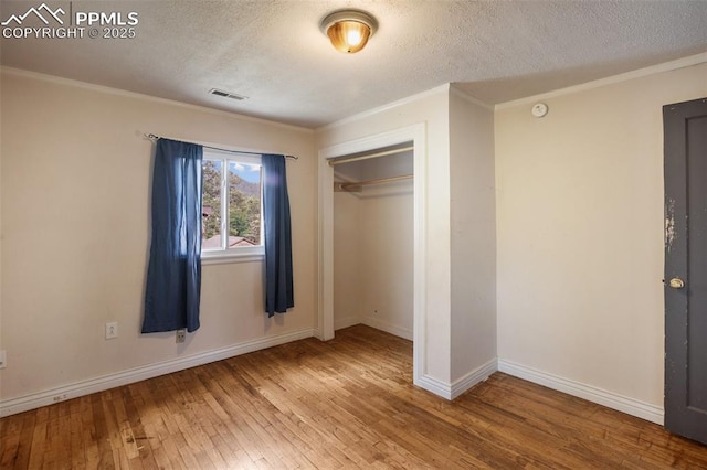 205 N Laurel St, Woodland Park, CO 80863 - unfurnished bedroom with hardwood / wood-style floors, a textured ceiling, a closet, and ornamental molding