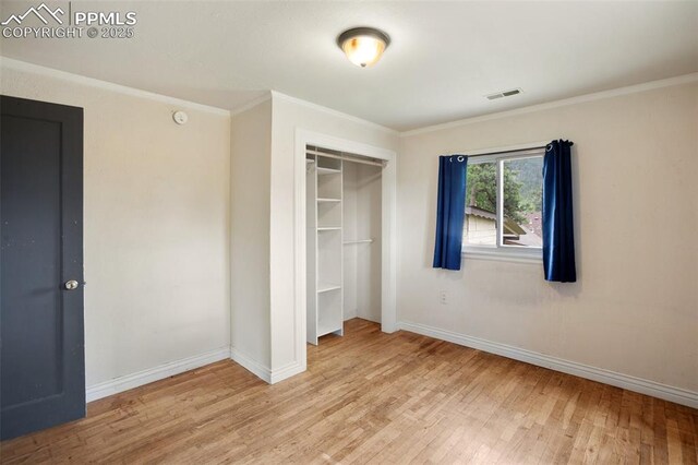 205 N Laurel St, Woodland Park, CO 80863 - unfurnished bedroom with wood finished floors, crown molding, and a closet