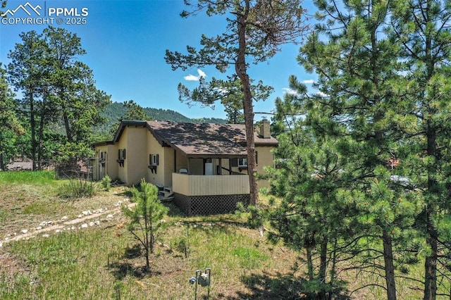 205 N Laurel St, Woodland Park, CO 80863 - view of side of home with stucco siding and a chimney